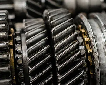 Close-up of several metal gears and shafts in an industrial gearbox