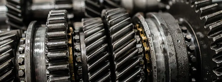 Close-up of several metal gears and shafts in an industrial gearbox