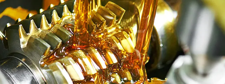 Close-up of heavily oiled metal gears as an example of lubricants in practical fluid management